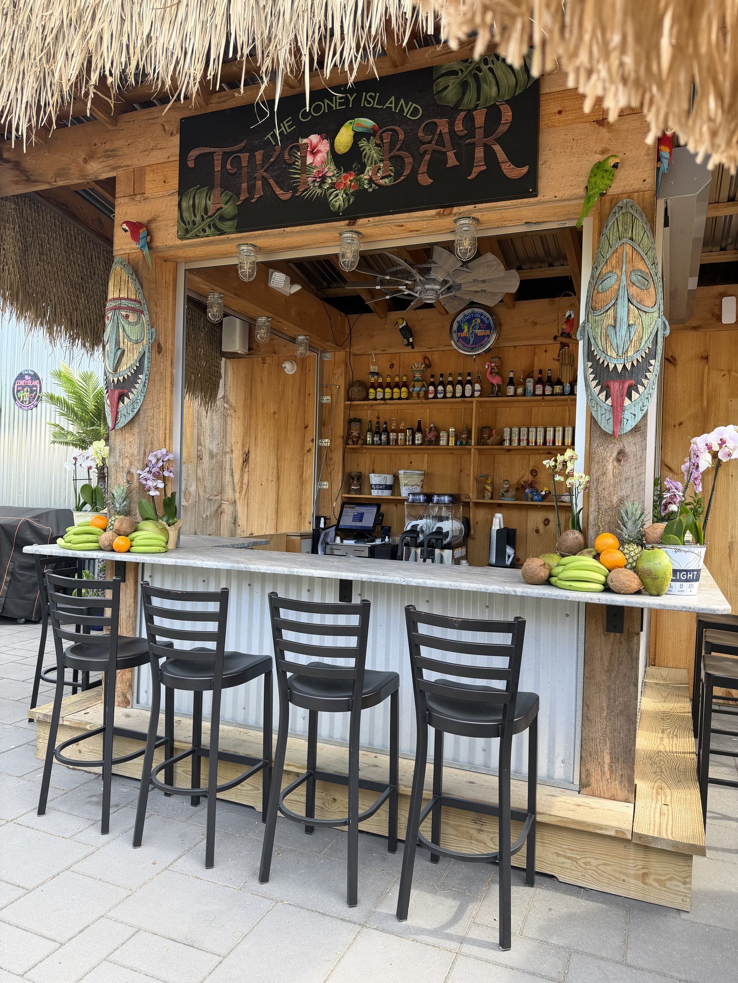 The Coney Tiki bar with stools and Welcome to the Coney Tiki sign