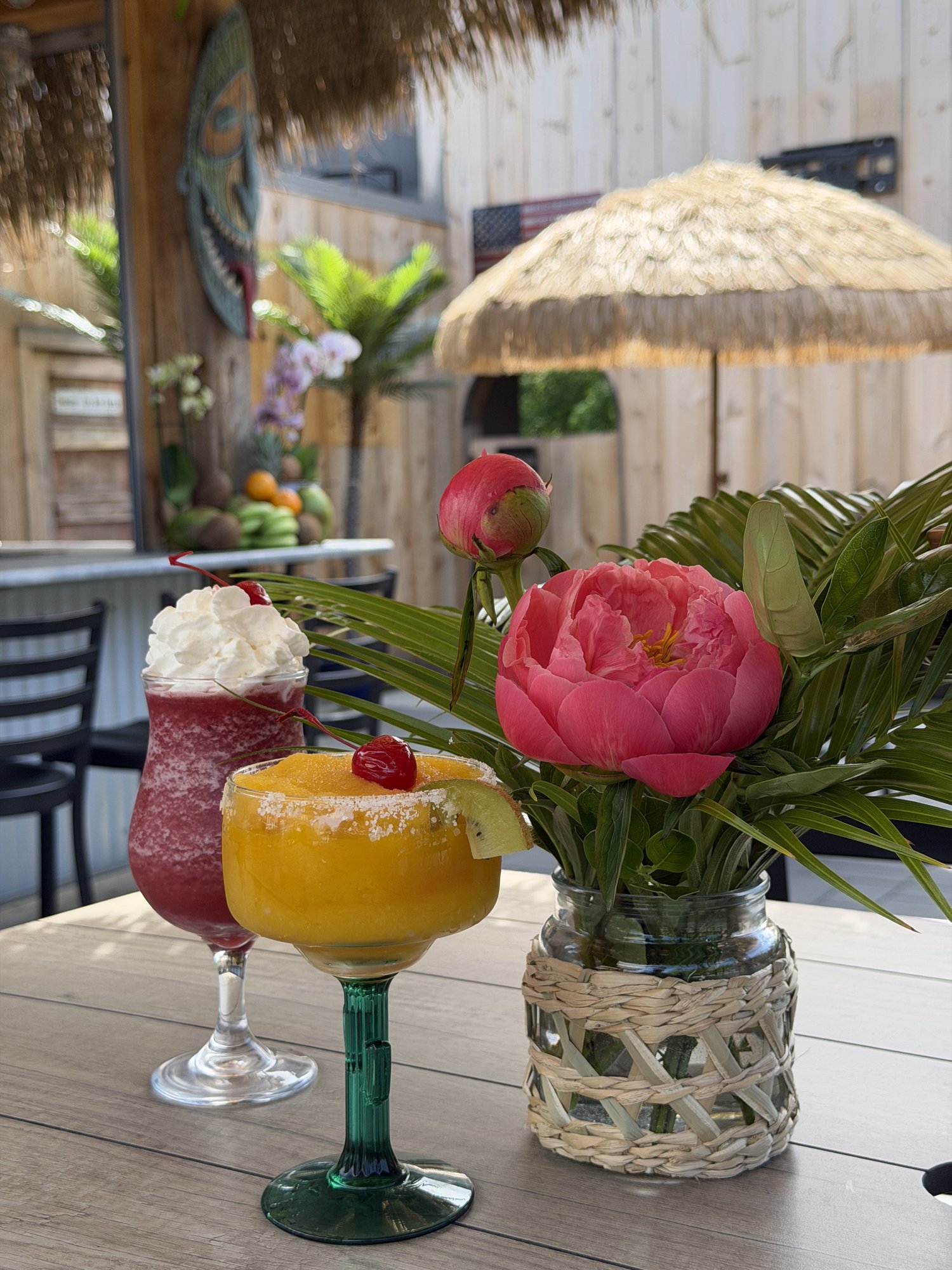 Tiki cocktail with carved tiki mask backdrop