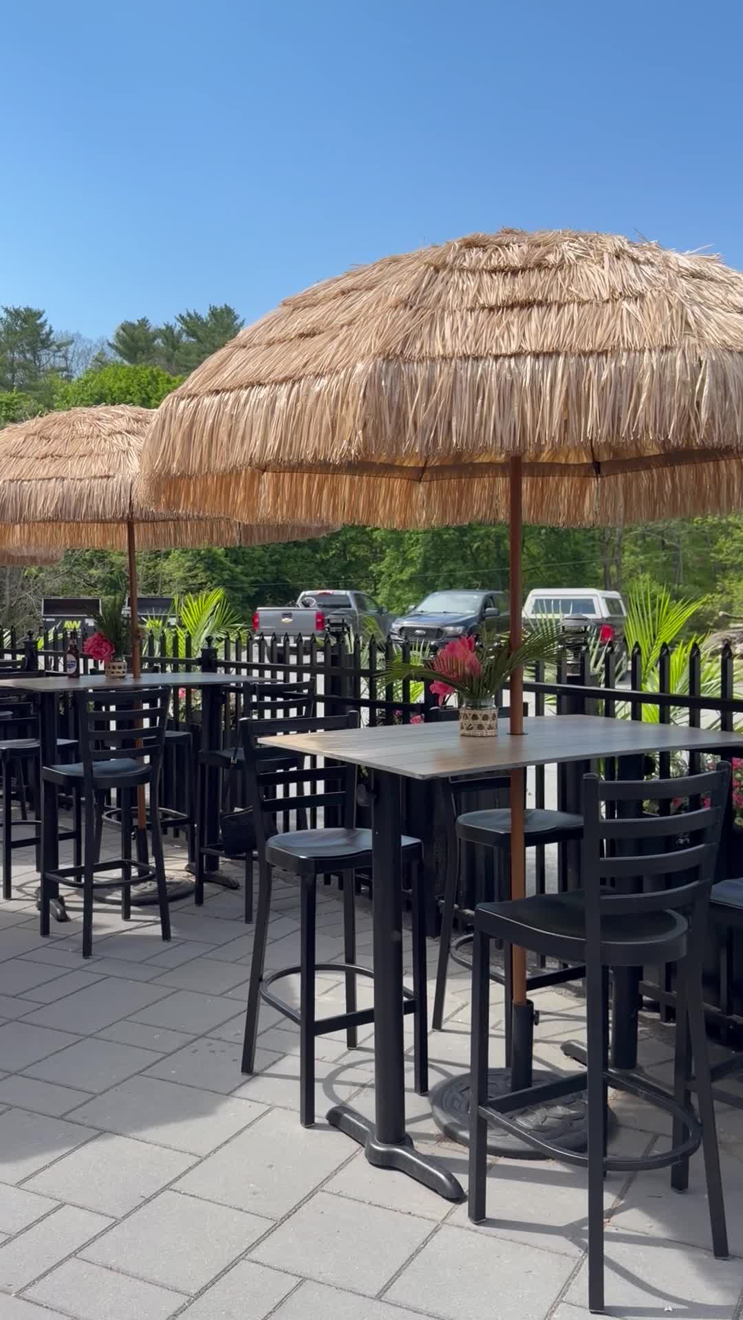 Thatched-roof umbrellas over patio tables